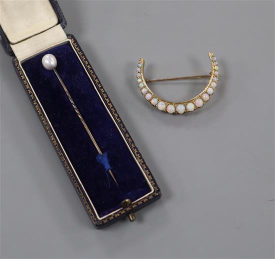A yellow metal and graduated white opal set crescent brooch and a cased tie pin.